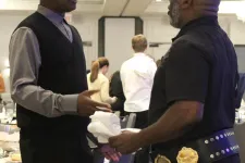 Thumbnail for a man handing another man a piece of paper