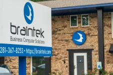 Thumbnail for Braintec business computer solutions sign with contact info in front of brick office building