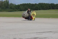 Thumbnail for two people walking back from sky diving