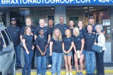 Thumbnail for a group of people posing for a photo in front of a building