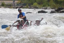 Thumbnail for people riding in a raft on the rapids
