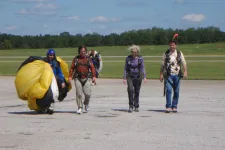 Thumbnail for people walking back from sky diving