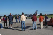 Thumbnail for a group of people standing around a plane