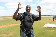 Thumbnail for a man standing on top of a grass covered field