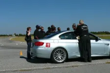 Thumbnail for people standing around a car on a test track
