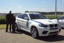 Thumbnail for a group of people standing in front of a car