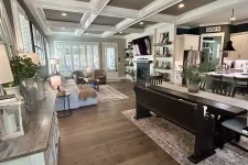 Thumbnail for Open-concept living and dining room with hardwood floors, coffered ceiling, white cabinetry, and farmhouse decor.