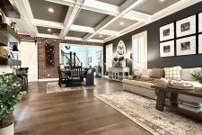 Thumbnail for Spacious living room with coffered ceiling, hardwood floors, sectional sofa, dining area, and dark accent wall with framed photos.