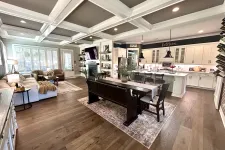 Thumbnail for Spacious open living room and kitchen with coffered ceiling, hardwood floors, white cabinetry, and modern furniture.