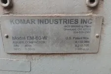 Thumbnail for Metal identification plate of Komar Industries Inc auger compactor model EM-60-W with patent numbers and manufacturing date.