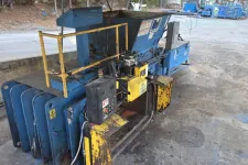 Thumbnail for Industrial metal baler machine with blue and yellow parts in a warehouse setting on concrete floor.