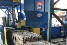 Thumbnail for Industrial Harris American cardboard baler compressing and bundling cardboard waste in a factory