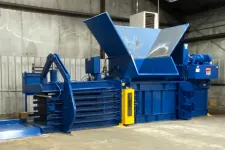 Thumbnail for Large industrial blue baler machine with hopper in a warehouse environment