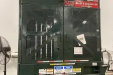 Thumbnail for Industrial PTR baler and compactor machine in warehouse setting with caution labels and metal mesh doors.