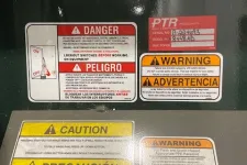 Thumbnail for Multiple bilingual safety labels including danger, warning, and caution notices on industrial equipment panel.