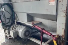 Thumbnail for Large industrial machine with electric motor, coiled cables, and red-yellow mechanical handles on metal frame.