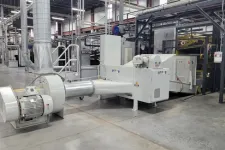 Thumbnail for Large industrial machine with motor and ducting in a clean modern factory setting.