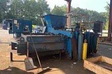 Thumbnail for Industrial metal baler machine with gas cylinders under a metal roof in an outdoor workshop area.