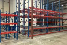 Thumbnail for Empty industrial blue and red metal storage racks on a concrete floor inside a warehouse.