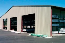 Thumbnail for Large outdoor storage warehouse with metal siding storing lumber and construction materials on racks.