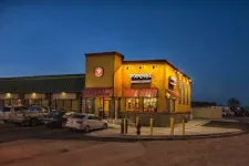 Thumbnail for Popeyes Louisiana Kitchen restaurant lit up at night with cars parked outside in the parking lot.