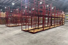 Thumbnail for Large empty red metal shelving units in a spacious warehouse with concrete floors and high ceilings.