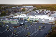 Thumbnail for Aerial view of a commercial gas station with attached bowling alley and empty parking lot at sunset.