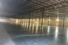 Thumbnail for Spacious empty industrial warehouse with polished concrete floor, high ceiling, and metal support beams