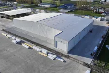 Thumbnail for Aerial view of a large industrial warehouse with surrounding storage and concrete pavement in a spacious facility.