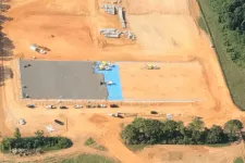 Thumbnail for Aerial view of a large construction site with concrete foundation work and surrounding earth moving activities.