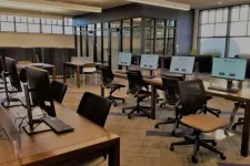 Thumbnail for Modern office workspace with multiple computer stations, ergonomic chairs, and large windows providing natural light.