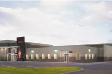 Thumbnail for Modern industrial building with MHC logo and parts entrance under a cloudy sky with parked cars.