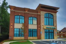 Thumbnail for Modern two-story First IC Bank building with large windows and brick exterior at dusk.