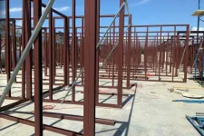 Thumbnail for Steel framework structure under construction on concrete floor with clear blue sky background.