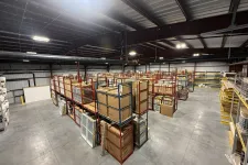 Thumbnail for Spacious warehouse with metal shelving racks storing boxed inventory and building materials under bright ceiling lights