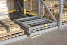 Thumbnail for Stacked cement bags on pallets in warehouse storage with metal shelving and industrial floor.