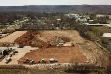 Thumbnail for Aerial view of large construction site with trucks and machinery preparing land in a suburban area.
