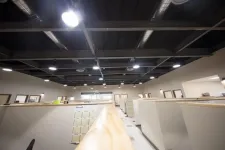 Thumbnail for Brightly lit modern office space with multiple cubicles and exposed ceiling ducts under fluorescent lighting.