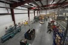 Thumbnail for Wide view of a clean, organized industrial workshop with machinery, shelving, and workstations under high ceilings.