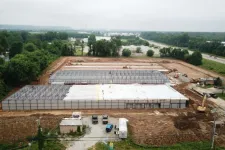 Thumbnail for Aerial view of a large industrial building under construction with steel framework and foundation laid out.