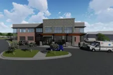 Thumbnail for Modern two-story medical building with ambulance, parked cars, and landscaped entrance under blue sky with clouds