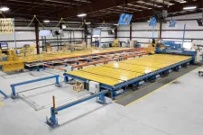 Thumbnail for Large industrial machine with yellow and blue components in a spacious factory setting under bright lights
