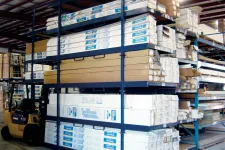 Thumbnail for Warehouse shelving stocked with boxed vinyl siding and construction materials with forklift nearby