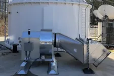 Thumbnail for Industrial ventilation system with metal ducts and fan installed on concrete surface outside a building.