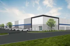 Thumbnail for Modern industrial building with parking lot, trees, and clear blue sky in a clean urban area.