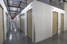 Thumbnail for Indoor storage facility with metal roll-up doors along clean polished concrete floors and metal roof framework.