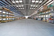 Thumbnail for Spacious industrial warehouse interior with high metal shelves stocked with construction materials and equipment.