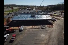 Thumbnail for Construction site with steel framework and crane assembling a large commercial building in an industrial area.