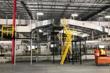 Thumbnail for Industrial warehouse with conveyor belts, yellow stairs, and RIDGID tool cart on concrete floor under metal roof