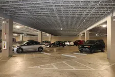 Thumbnail for Indoor parking garage with multiple cars parked and concrete pillars supporting the ceiling structure.